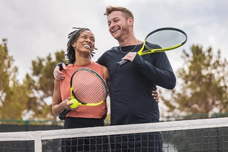 Couple holding tennis rackets